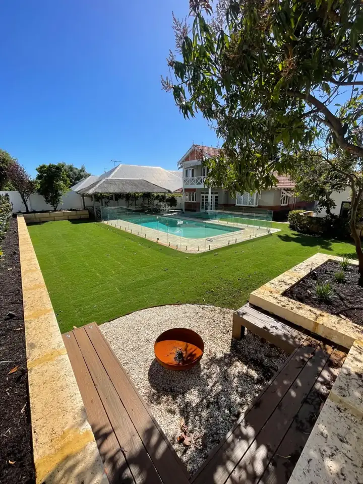 Fire pit, timber bench and raised planter looking back to the pool
